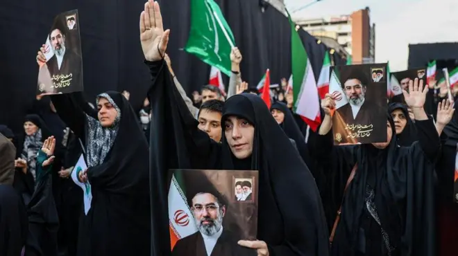 तेहरान में 9 मार्च को हुई रैली में मोजतबा ख़ामेनेई की तस्वीर लिए लोग