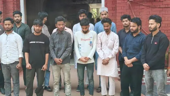 पुलिस के साथ खड़े 14 युवक