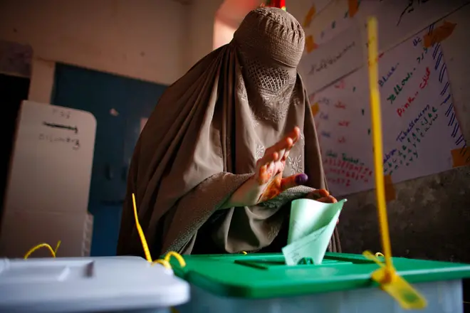 خاتون بیلٹ باکس میں ووٹ ڈال رہی ہیں