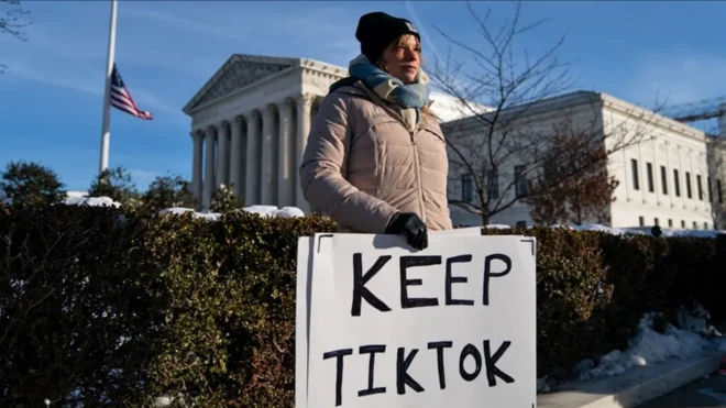 Девушка с плакатом «Сохраните TikTok»