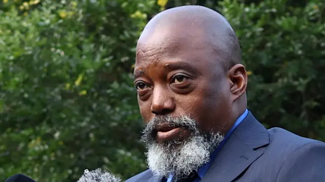 Gros plan de Joseph Kabila, crâne rasé et barbe, vêtu d'un costume bleu foncé. Il s'exprimait à Johannesburg, en Afrique du Sud, le 18 mars 2025.