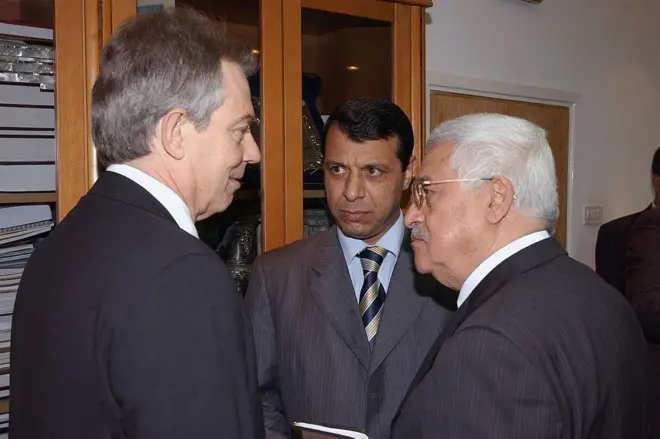 دحلان يتوسط أبو مازن، يمينا، وتوني بلير في أثناء زيارة رئيس الوزراء البريطاني إلى رام الله في أواخر عام 2006 ضمن جولة شرق أوسطية استهدف إحياء عملية السلام إثر توترات في غزة عقب فوز حماس بالانتخابات.