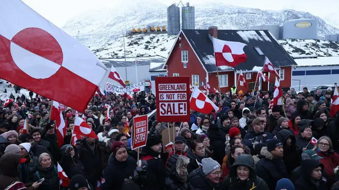 Pessoas com cartazes e bandeiras da Groenlândia se reúnem perto do Consulado dos Estados Unidos na capital groenlandesa, Nuuk, para protestar