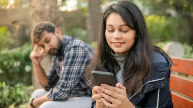 मोबाइल फ़ोन देख रही महिला