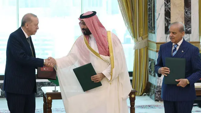 Erdoğan bin Selman ile tokalaşıyor, sağda Şahbaz Şerif onlara bakıyor