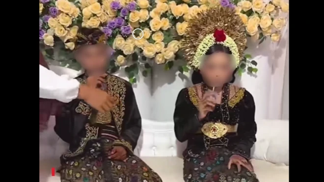 Sepasang pengantin duduk di pelaminan.
