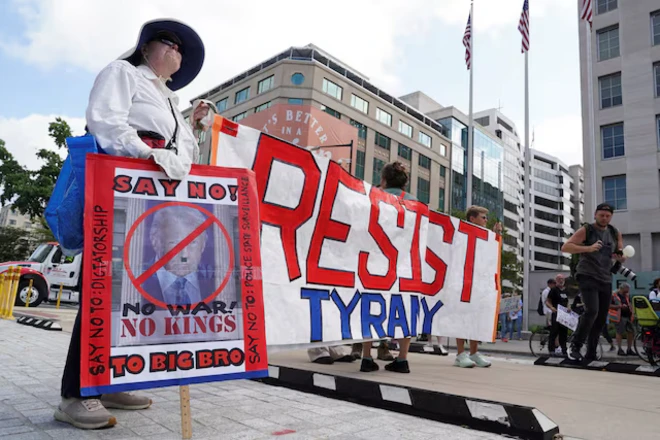 Những người biểu tình giương cao biểu ngữ gần Nhà Trắng, sau khi Tổng thống Mỹ Donald Trump tuyên bố ông sẽ đặt Sở Cảnh sát Thủ đô D.C. dưới sự kiểm soát trực tiếp của liên bang và triển khai Vệ binh Quốc gia tới Washington. Ảnh chụp ngày 11/8/2025