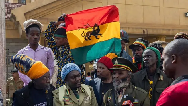 ራስ ተፈሪያን አንበሳ ያለበት አረንጓዴ፣ ቢጫ ፣ ቀይ ቀለም ያለው ሰንደቅ ዓላማ ይዘው
