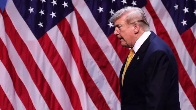 Дональд Трамп на фоне флагов США