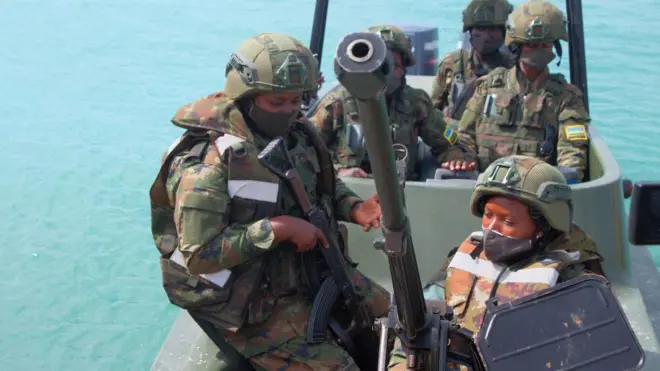 Abasirikare b'u Rwanda barimo babiri bagaragara ko ari abagore, umwe muri bo afite imbunda ya rutura, bari ku irondo mu bwato, mu mujyi uri ku cyambu wa Mocimboa da Praia, mu majyaruguru ya Mozambique, ku itariki ya 13 Kanama (8) mu 2021. Bambaye udupfukamunwa, impuzankano za gisirikare n'ingofero zikomeye za 'casques' za gisirikare, babiri muri bo bambaye amajaketi arinda kurohama mu mazi. 