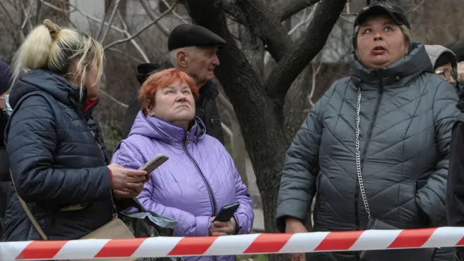 Жители Днепра после эвакуации из дома, пострадавшего в результате удара