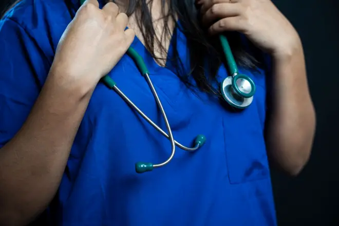 Young female doctor in surgical scrubs with a stethoscope