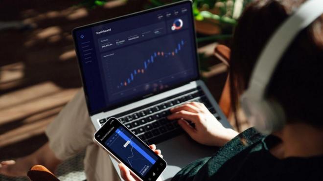 مردی در حال کار کردن با لپ تاپ و گوشی همراه