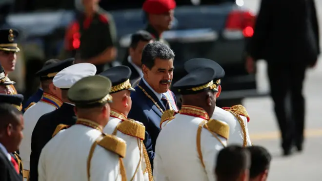 Maduro, um homem branco,casas de apostas corridas de cavaloscabelos grisalhos e bigode, está no meiocasas de apostas corridas de cavalosvários homens vestidos com uma roupa formal branca e boina