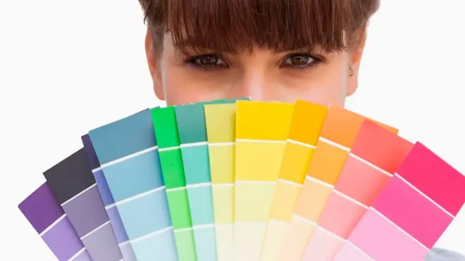 Дічина тримає зразки різних кольорів