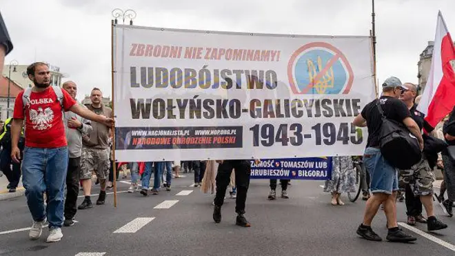 Протестувальники несуть банер з написом "Волинсько-галицький геноцид 1943-45 років" із зображенням перекресленого українського тризуба під час демонстрації у Варшаві, Польща, 12 липня 2026 року