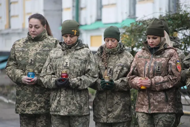 Ellerinde birer mum tutan dört kadın asker