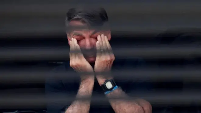 رئيس البرازيل السابق جايير بولسونارو وهو يضع يديه على عينيه