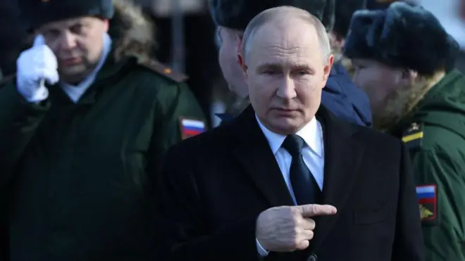 Le président russe Vladimir Poutine, accompagné d'officiers militaires ayant participé à l'invasion militaire de l'Ukraine, assiste à une cérémonie de dépôt de gerbes sur la tombe du soldat inconnu.