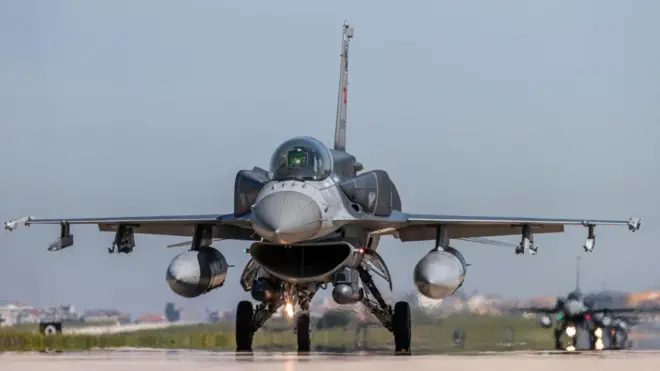 Bir F-16 savaş uçağını kalkış anında görüyoruz, arkasında bir uçak daha var.