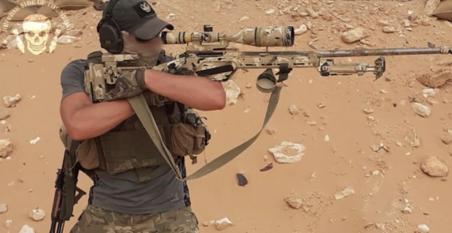 A Wagner sniper in Libya is seen in a desert environment with a specialised sniper rifle 