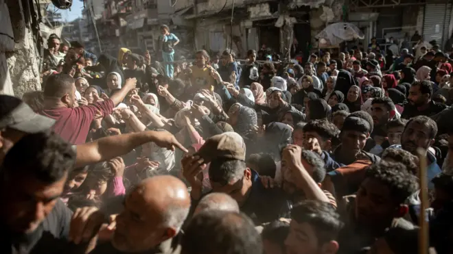 غزيون يصطفون أمام شاحنات المساعدة