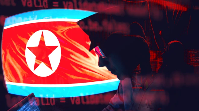 북한 국기를 배경으로 한 사람이 컴퓨터 화면을 들여다 보고 있는 이미지 