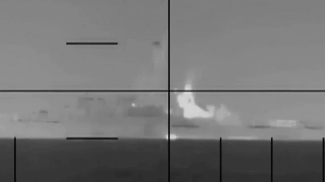 تصویری سیاه و سفید و مدرج که به نظر مربوط به دوربین جنگی باشد، در دوردست ناوی را نشانه گرفته است، روی تصویر نوشته شده طبقه‌بندی نشده