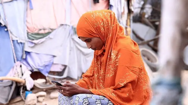 Dubartii Moobaayilii ilaalaa jirtu