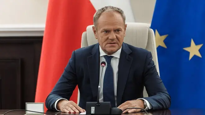 Polşanın Baş naziri Donald Tusk, arxada Polşa və Avropa İttifaqının bayraqları.