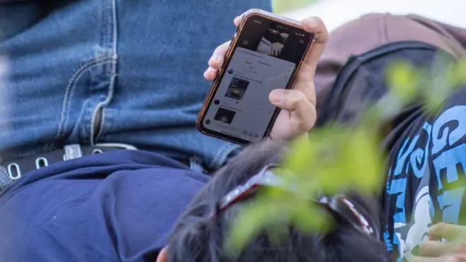 дечак гледа у телефон