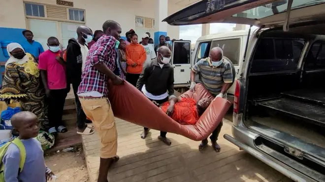 Kongo'da bir Ebola hastası adam hastaneye taşınıyor. İki adamın hastayı kamyonetin arkasına yerleştirmeye çalıştığı görülüyor.