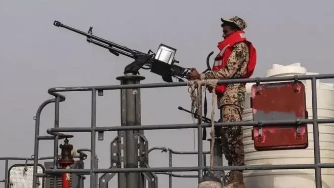 Mwanamaji wa Jeshi la Wanamaji la serikali ya Yemen inayotambuliwa kimataifa amesimama kando ya bunduki ya mashine kwenye sitaha ya boti ya doria karibu na Kisiwa cha Hanish katika Bahari ya Shamu. Doria hiyo inafanyika wakati mvutano na vitisho dhidi ya usafiri wa meli katika eneo hilo vimeongezeka.