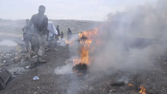 People burning things in an open field