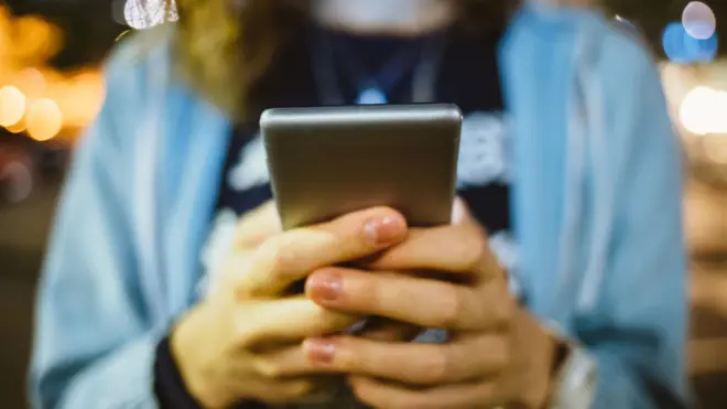 žena drži telefon