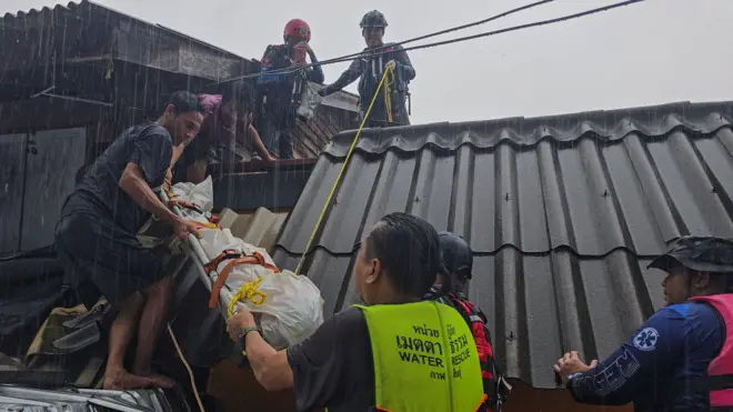 Members of rescue teams carry the body of a victim out of his home which is partially submerged in a flooded area in Hat Yai district, which has been affected by heavy rainfall that has hit 10 provinces in southern Thailand and killed several people, in Songkhla province, Thailand, November 24, 2025. 