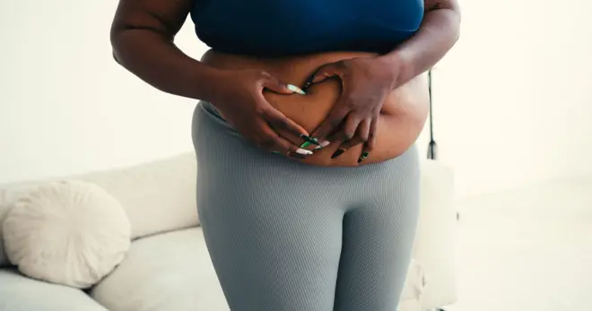 Femme qui,pose ses mains sur son ventre