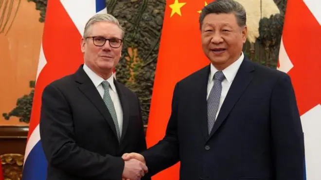 共にダークスーツ姿の両首脳が国旗を背に握手しながらカメラを見ている。両者ともわずかに笑顔を見せている