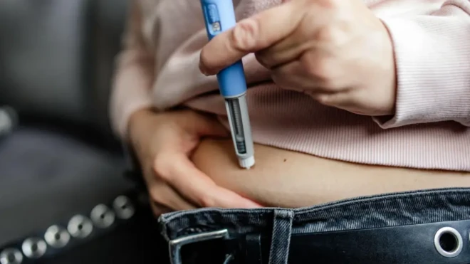 فردی در حال تزریق آمپول لاغری به شکم خود