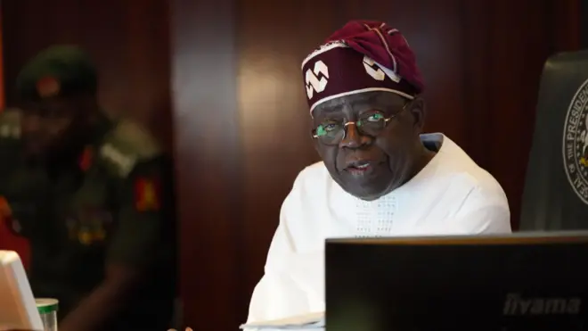 Aarẹ Tinubu pẹlu aṣọ funfun ati fila idanimọ rẹ