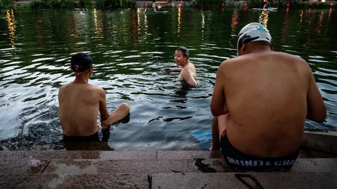三名男子在河中游泳避暑