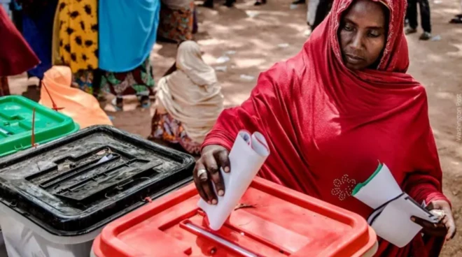 Woman wey dey cast her vote into di ballot paper