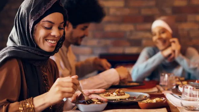 Trois personnes à une table d'iftar