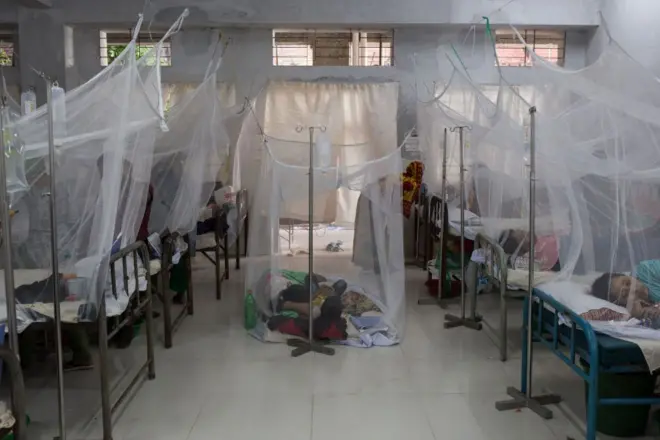 হাসপাতালের বেডে জায়গা না হওয়ায় মেঝেতে মশারী টানিয়ে শুয়ে আছে রোগী 