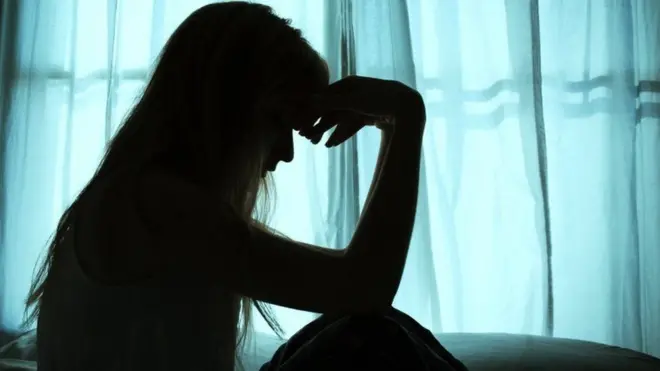 ኣብ ጥቓ መስኮት ኮፍ ዝበለት ሰበይቲ 