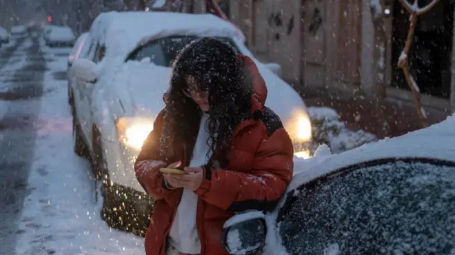 دختری در تهران موبایلش را چک می‌کند