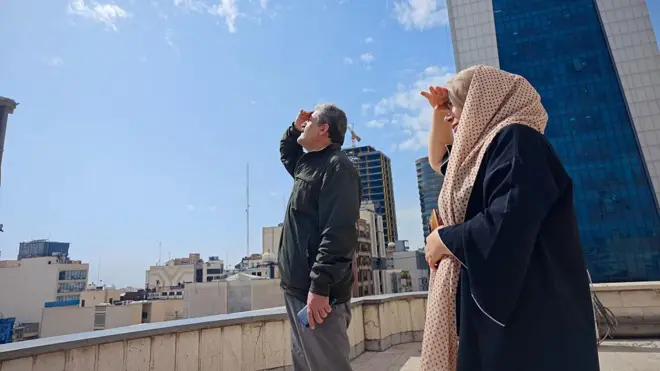 İran'ın başkenti Tahran'da gökyüzüne bakan bir kadın ve bir erkek