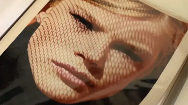 Picture in an album showing an artistic headshot of a young blonde woman looking into the camera.