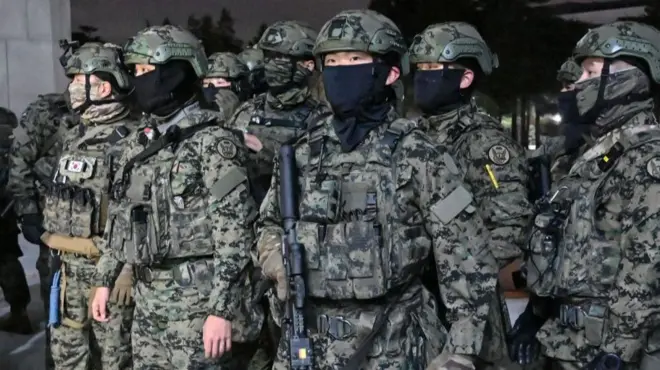 Soldados surcoreanos intentando ingresar al Parlamento.