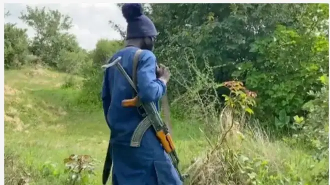 Aworan agbebọn ọkunrin ninu igbo, o de fila dudu, wọṣọ alawo aro